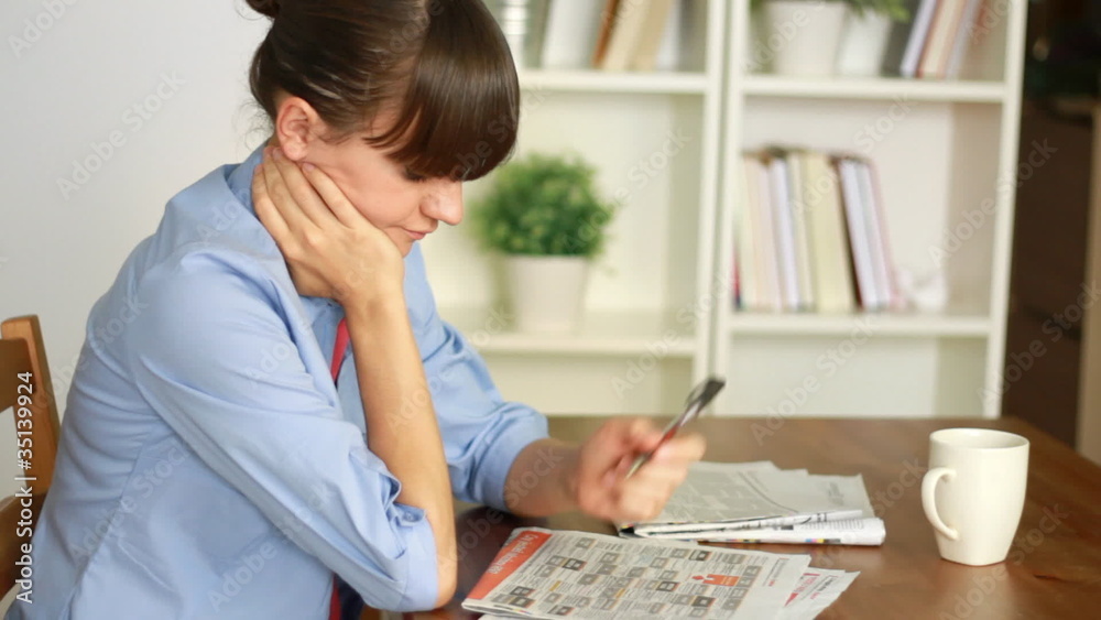 Young attractive woman looking in newspaper for job