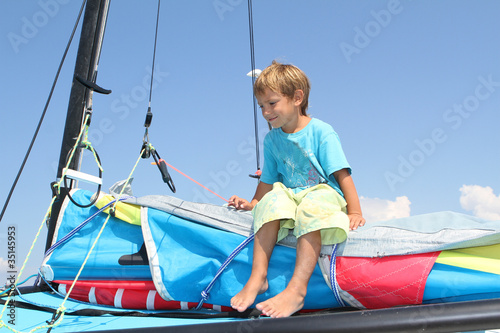 young boy on board of sea catamaran