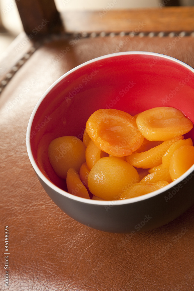 Peach halves in syrup, in a deep bowl,on a leather surface. Peach halves in syrup, in a deep bowl,on a leather surface.