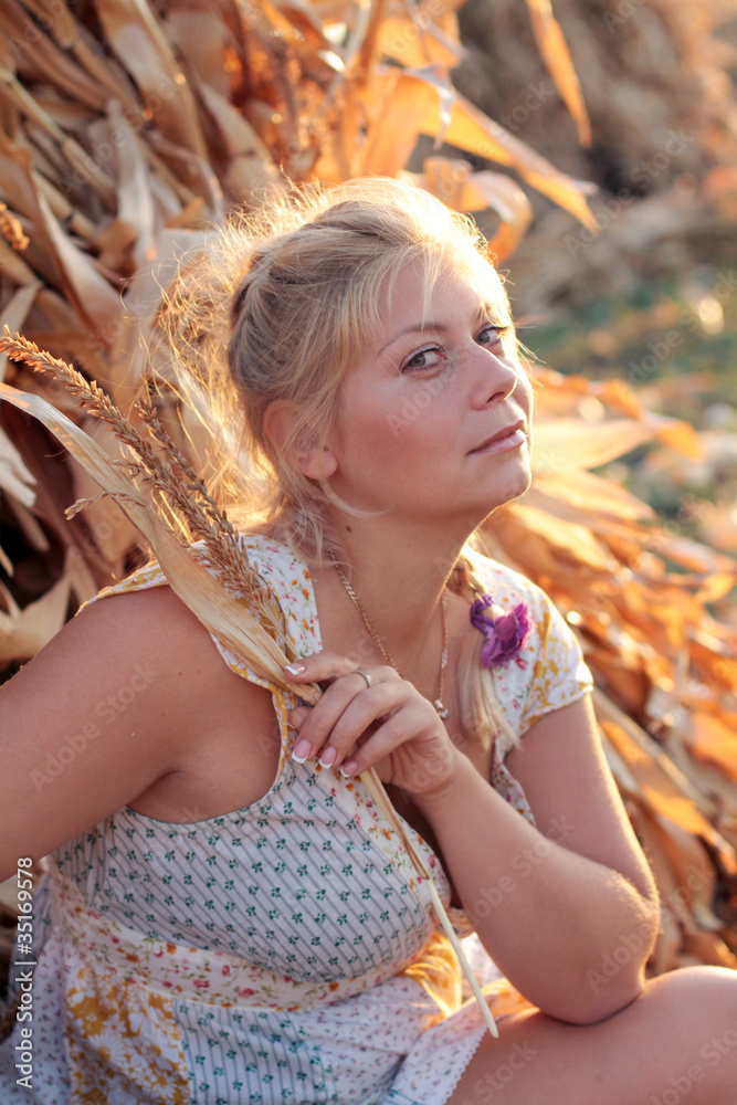 Naklejka premium Young woman in corn haystack