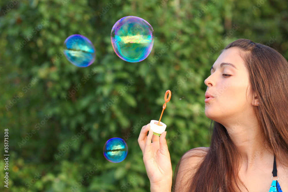 Pretty woman inflating soap-bubbles Pretty woman inflating soap-bubbles
