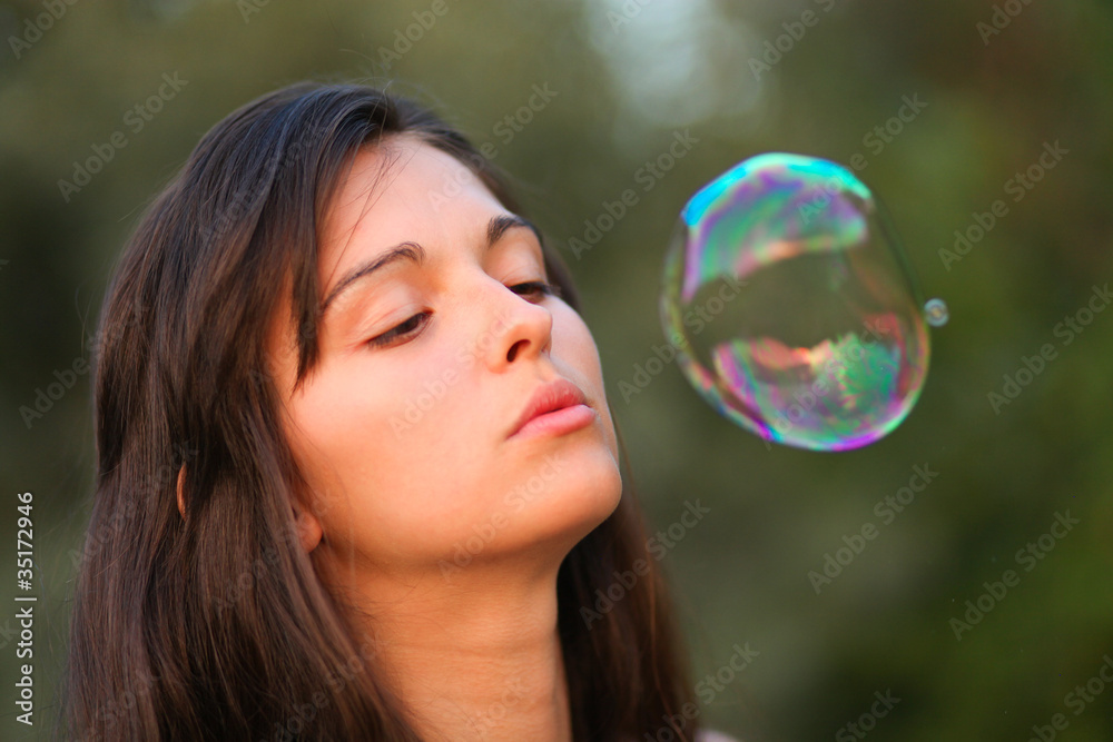 Pretty woman inflating soap-bubbles Pretty woman inflating soap-bubbles