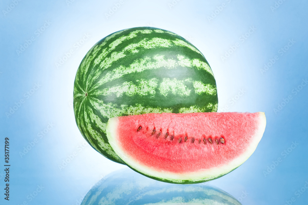Ripe Watermelon and Slice isolated on a blue background Ripe Watermelon and Slice isolated on a blue background