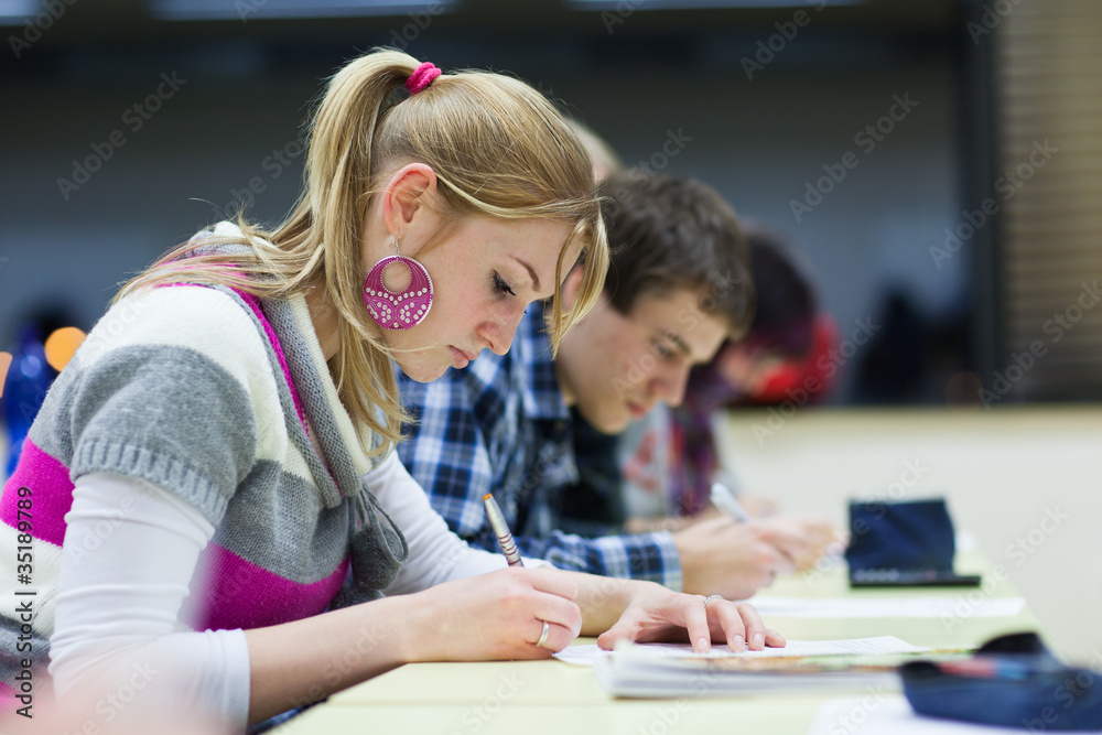 pretty female college student sitting in a classroom pretty female college student sitting in a classroom