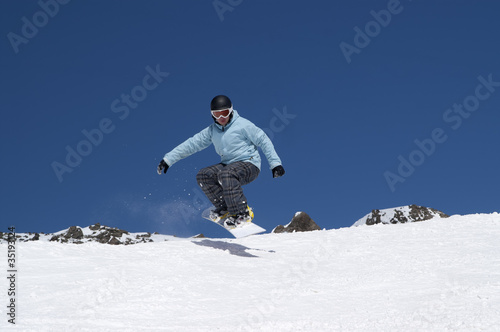 Snowboarder jumping in the mountains