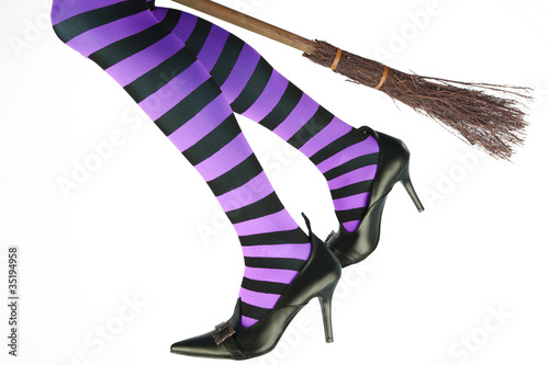 Stripey legged witch flying on a broomstick. photo