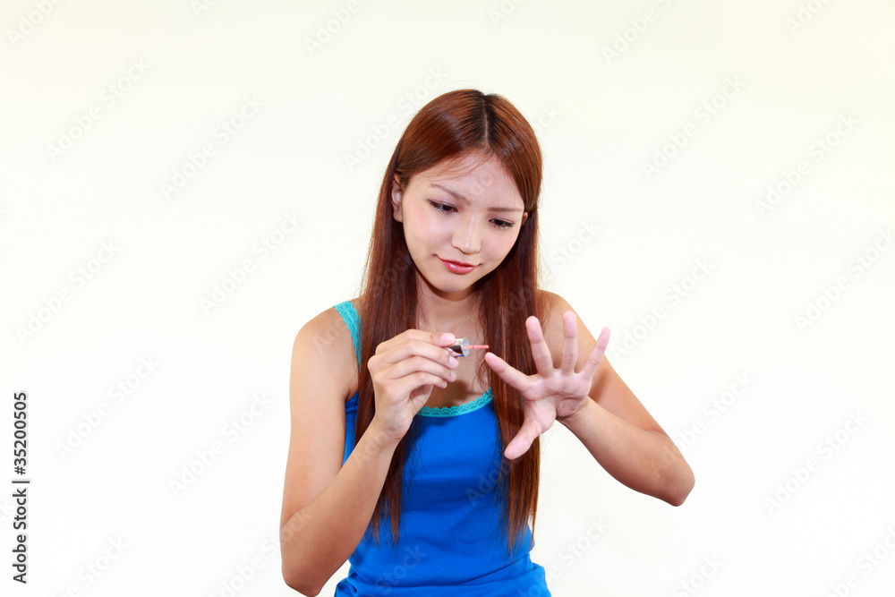 爪のコーティングをする女性 爪のコーティングをする女性