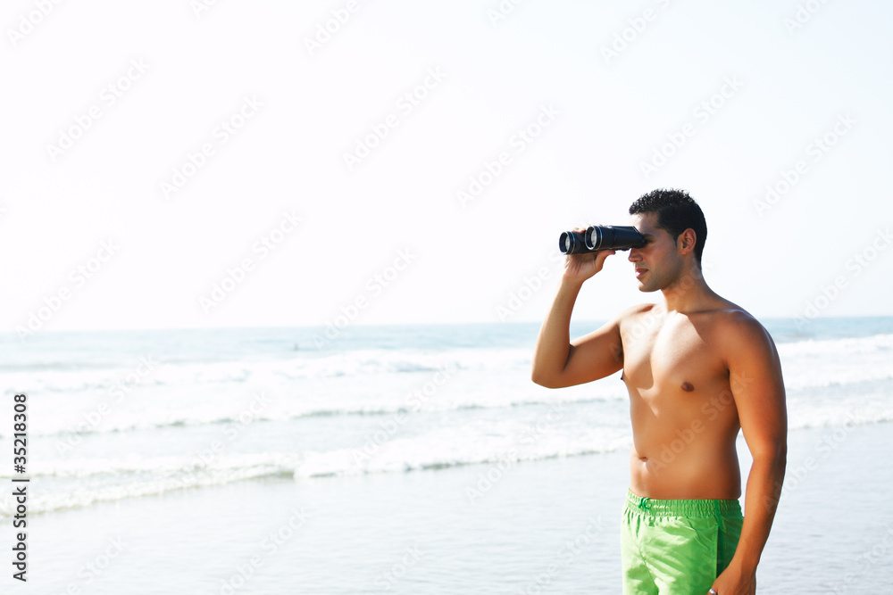 Obraz premium boy with binoculars looking at the seashore