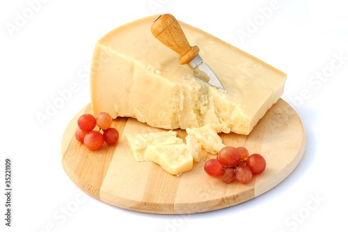 italian cheese on wooden cutting board with red grapes