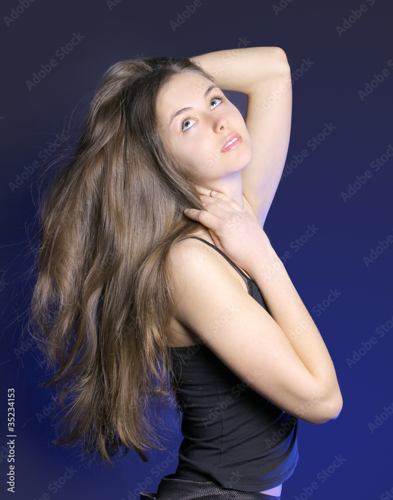 Naklejka premium The beautiful young woman on a dark background
