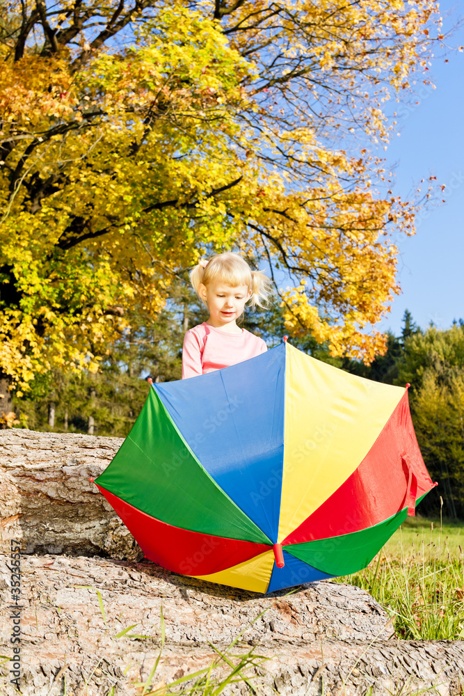 little girl with umbrella in autumnal nature