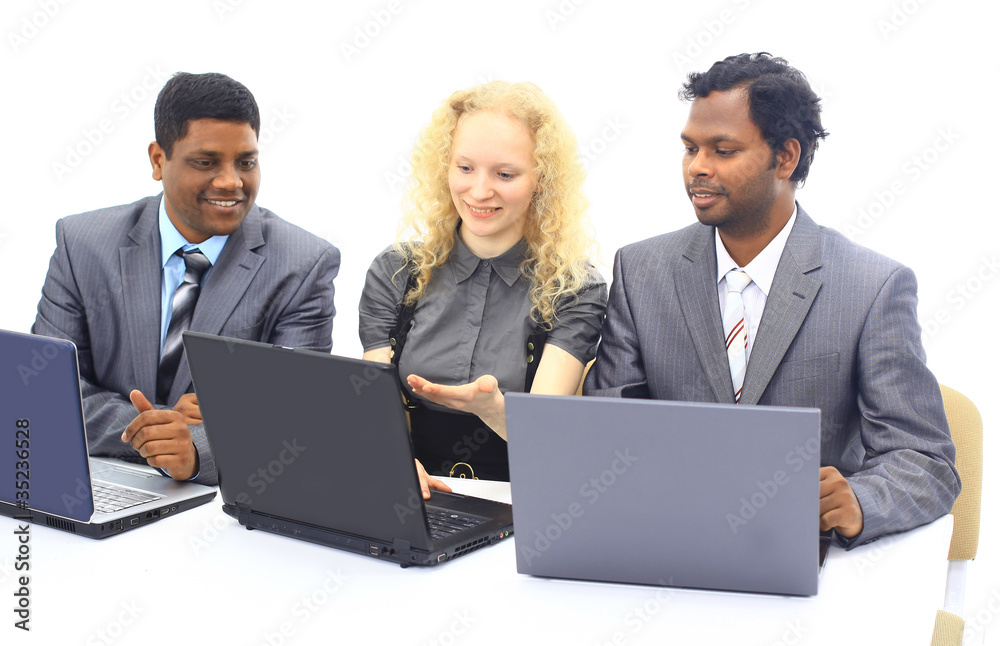 Interracial business team working at laptop in a Interracial business team working at laptop in a