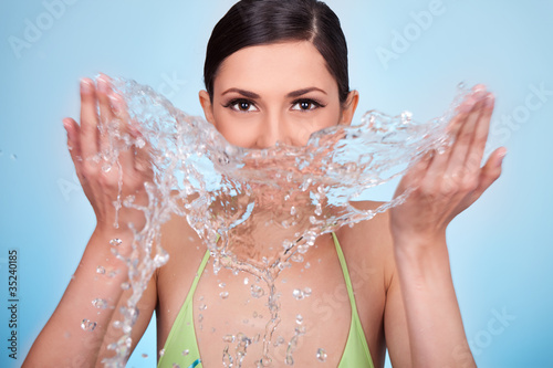 woman cleaning her face with water