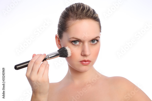 Beautiful woman using stippling make up brush