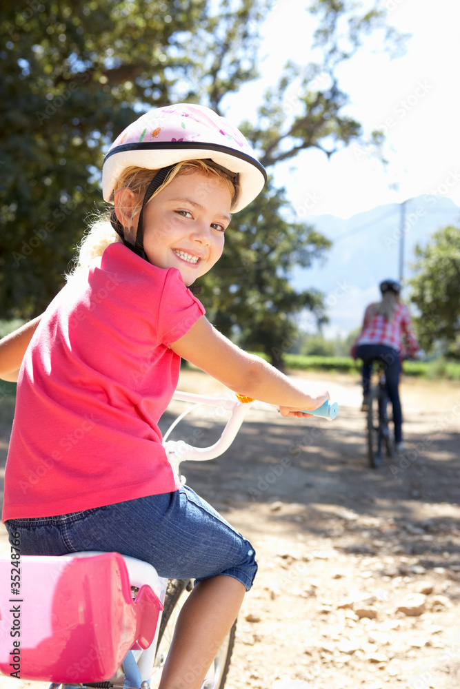 Little girl on country bike ride with mom Little girl on country bike ride with mom