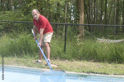 homeowner cleaning swimming pool