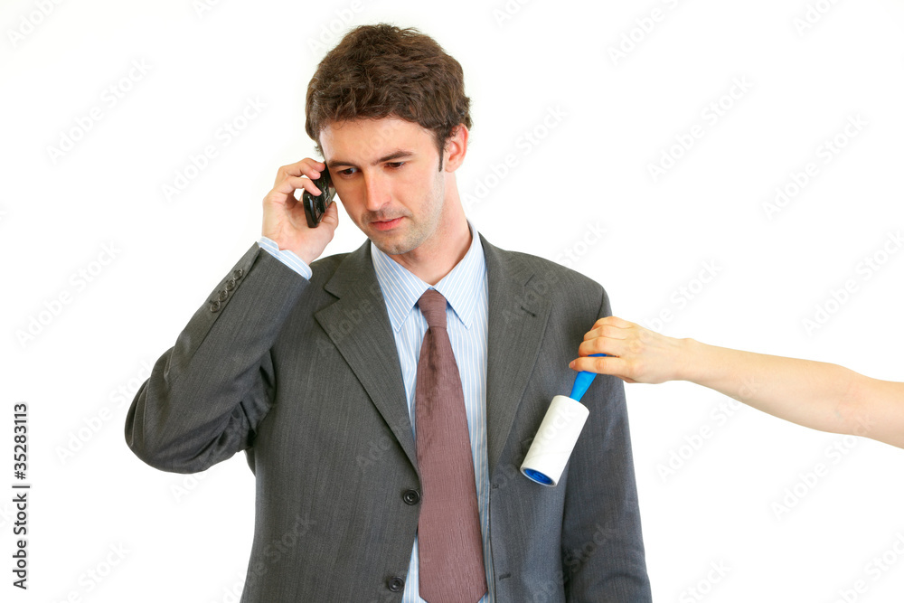 Secretary cleaning chiefs suit while he talking on phone Secretary cleaning chiefs suit while he talking on phone