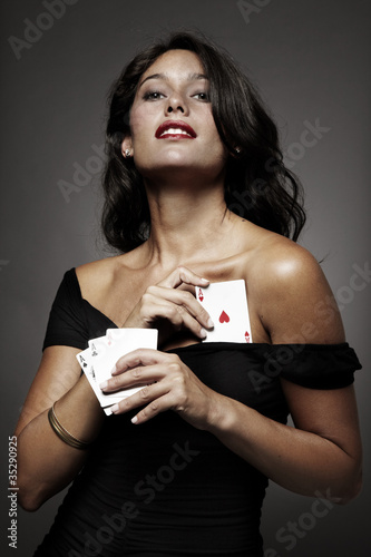 mujer atractiva jugando al poker escondiendo un as en el vestido photo