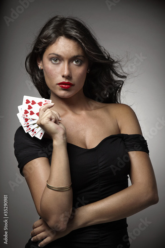 mujer atractiva jugando al poker con escalera de color photo