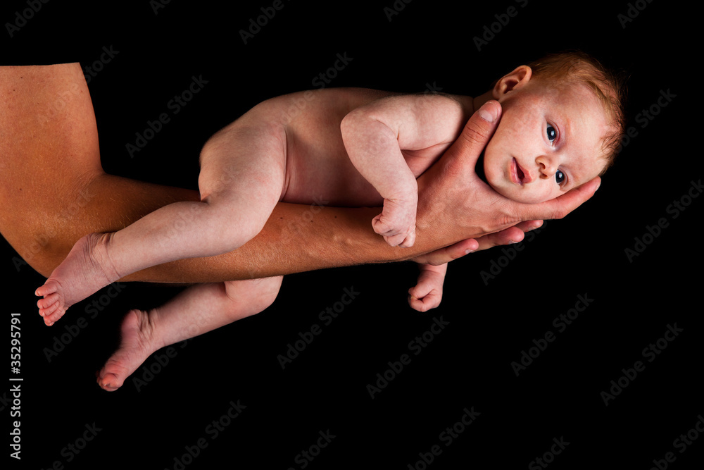 Infant girl on fathers arms isolated on black Infant girl on fathers arms isolated on black