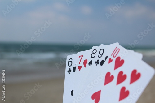 Poker hand - Straight Flush, with beach background