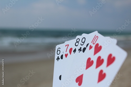 Poker hand - Straight Flush, with beach background