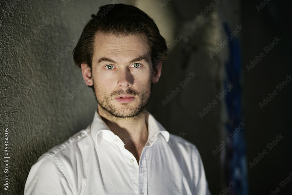 Fototapeta premium Mann im Hemd an der Wand