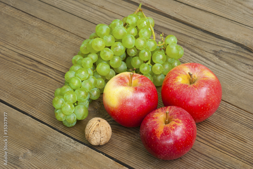 apples , nut and grapes on wooden table apples , nut and grapes on wooden table