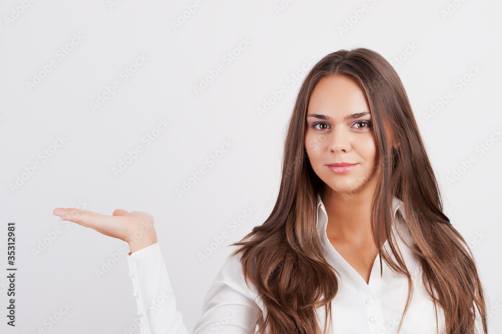 Happy smiling young business woman showing blank area for sign o Happy smiling young business woman showing blank area for sign o