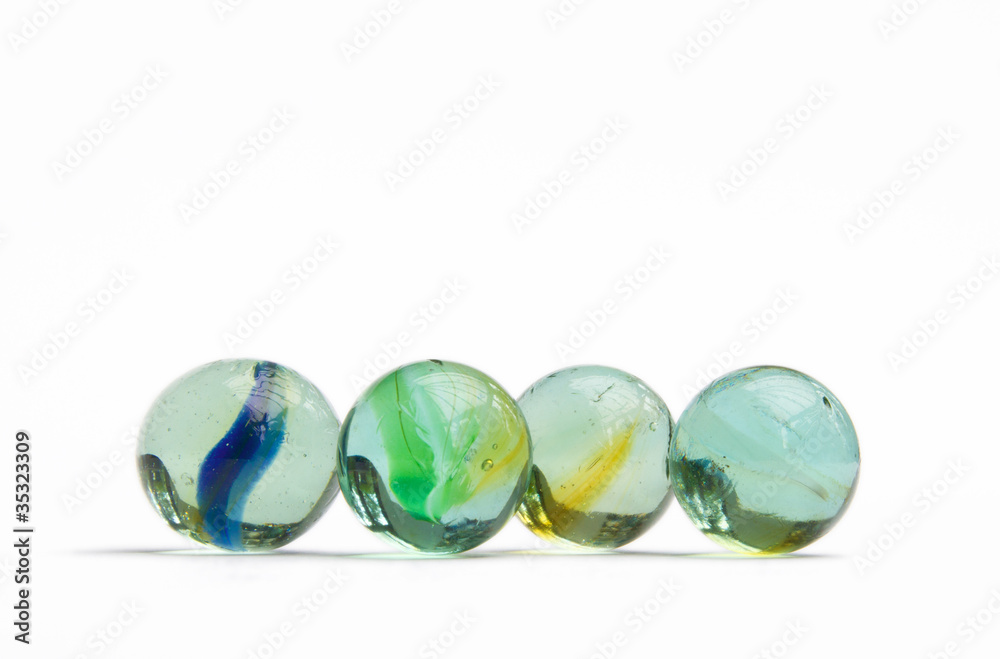 4 coloured glass marbles on white background 4 coloured glass marbles on white background