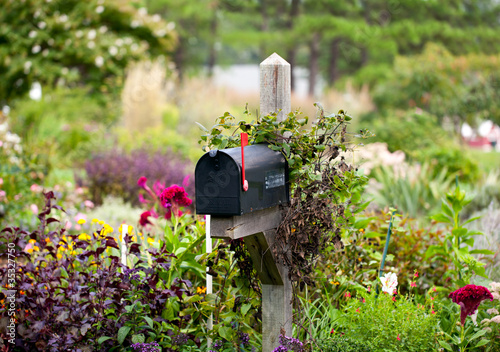 Fotografia US mailbox with flag raised in flowers