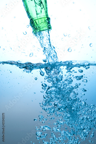 Green bottle and water splashing