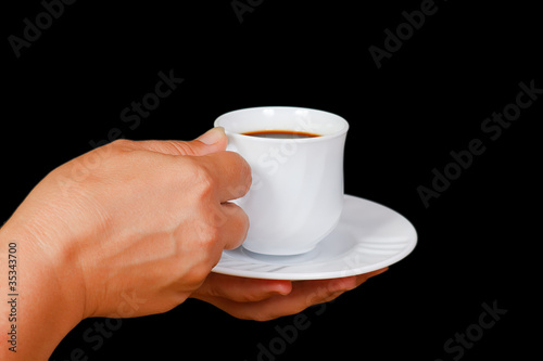 Hands with a cup of coffee on a black background