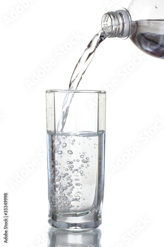 Pouring water on glass isolated on white
