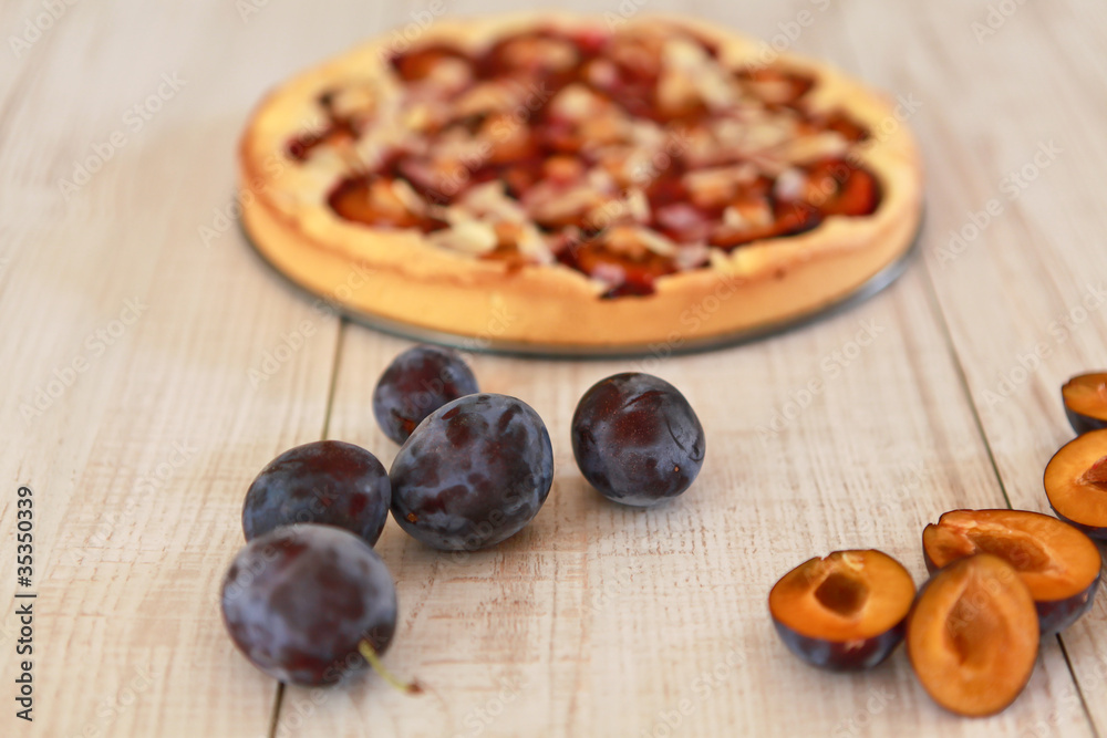 Plum pie and on a wooden white background