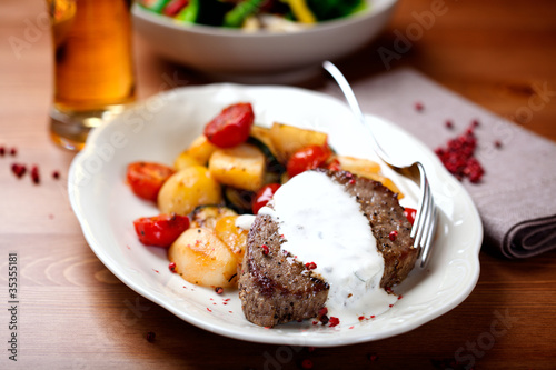 Beef steak with herb sauce and roasted vegetables