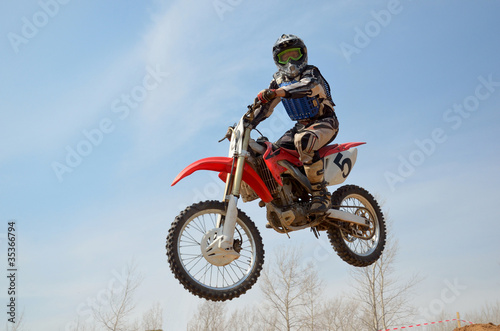 Motocross motorbike racer performs a jump efficient