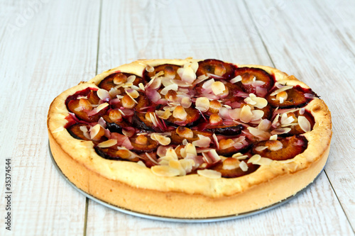 Plum pie and on a wooden white background