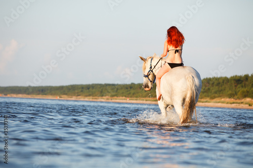 Woman swimming with horse
