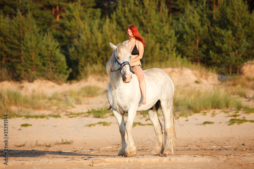 Woman with horse at the beach