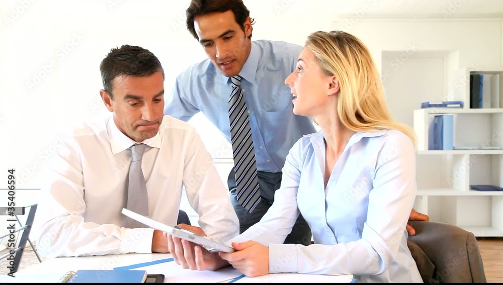 Business team using electronic tablet in office Business team using electronic tablet in office