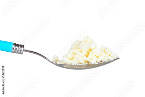 Tasty cottage cheese in spoon isolated on white