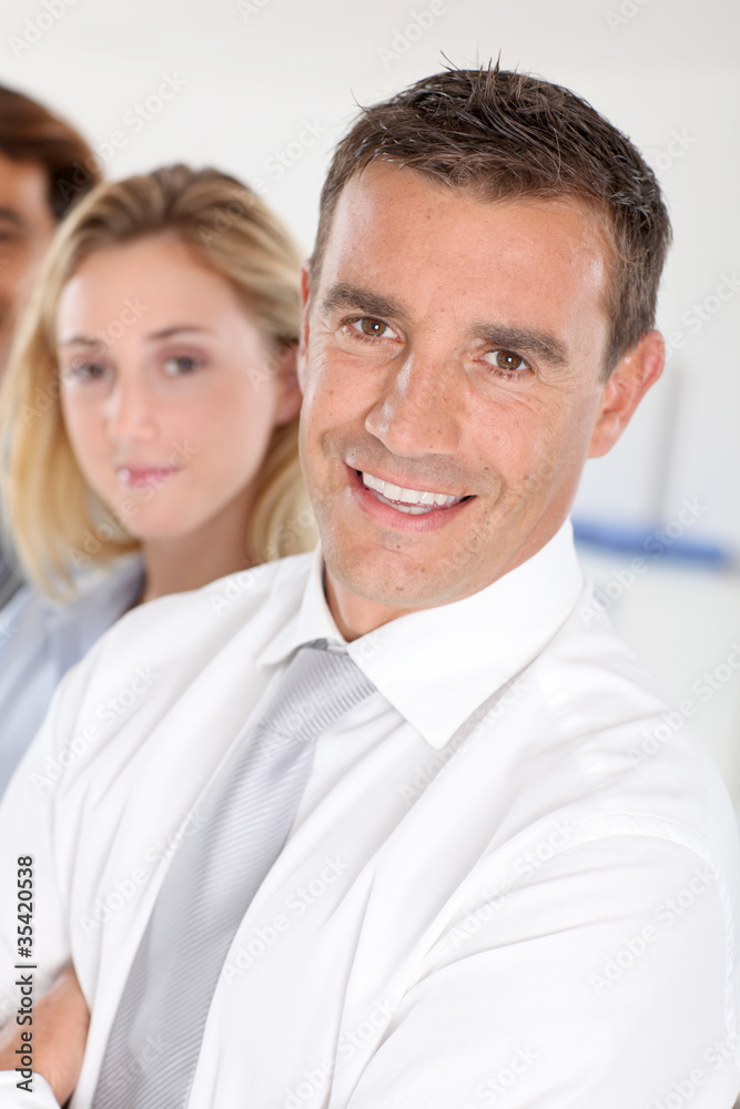 Portrait of businessman standing in front of group Portrait of businessman standing in front of group