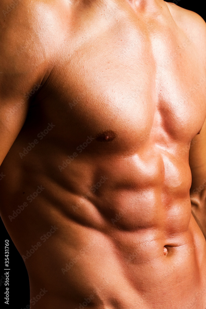 Beautiful naked muscled torso against black background