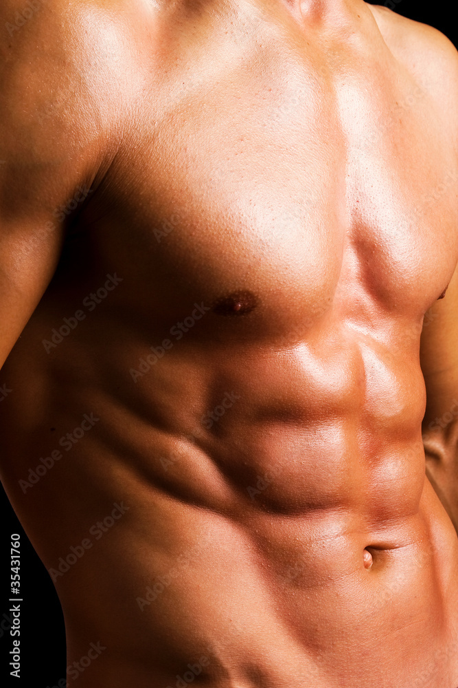 Beautiful naked muscled torso against black background Beautiful naked muscled torso against black background