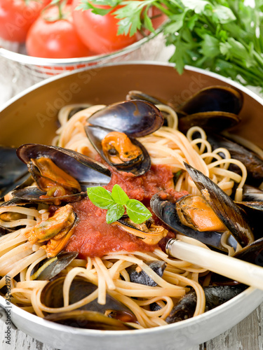 spaghetti with mussels and tomato sauce over casserole