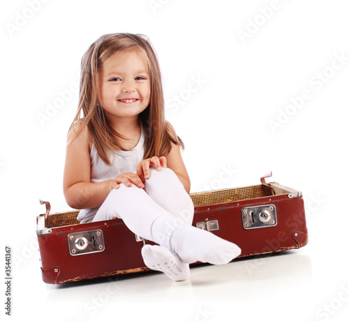 Happy small child sitting in a suitcase. Travel concept. Isolate