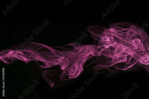 Abstract pink colored smoke, black background. photo