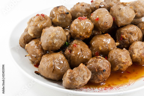 Meatballs with sauce in white dish.