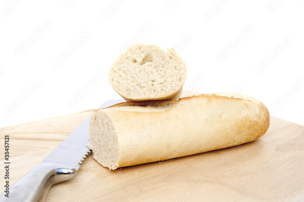 Baguette and bread knife on chopping board isolated on white Baguette and bread knife on chopping board isolated on white